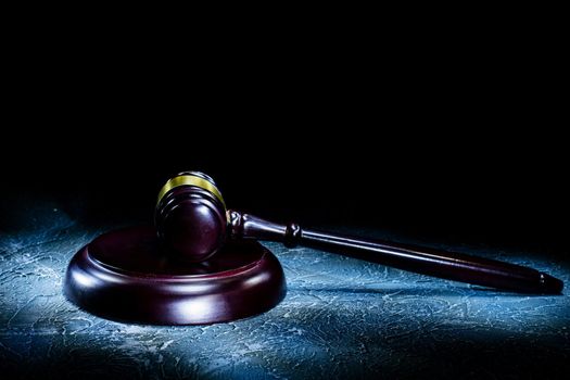 Judge's gavel lies on a stone table. Picture taken with a light brush - Image