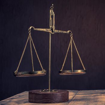 Law scales on table. Symbol of justice - Image Toned