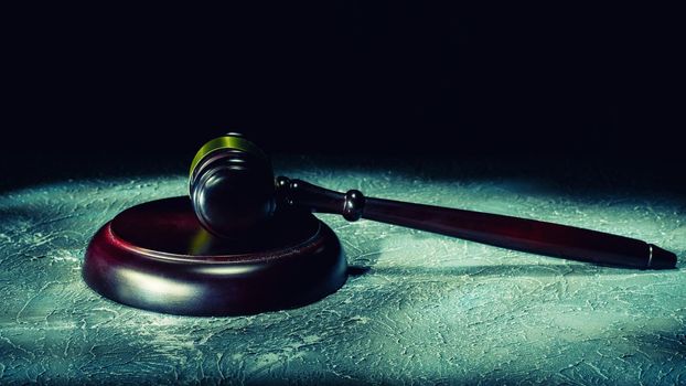 Judge's gavel lies on a stone table. Picture taken with a light brush - Image