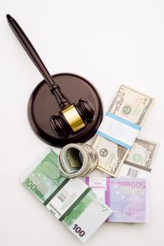 Top view Judge's gavel and packs of dollars and euro banknotes on a white background. The concept of growing national debt- image
