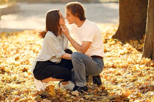 Couple in a park. Guy in a white t-shirt. Golden autumn.