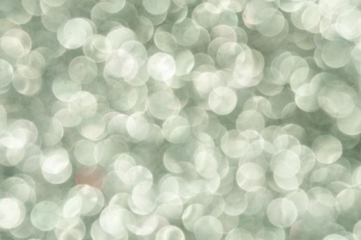 Silver Sparkling Lights Festive background with texture. Abstract Christmas twinkled bright bokeh defocused and Falling stars. Winter Card or invitation