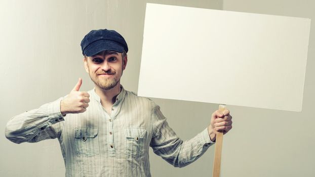 Amazed bearded man showing thumb up and leaning at copy space while standing against white background