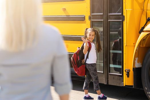 Beautiful small girl with mother near school