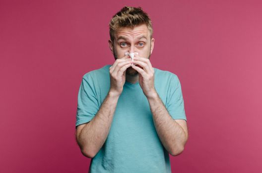 studio picture from a young man with handkerchief. Sick guy isolated has runny nose. man makes a cure for the common cold