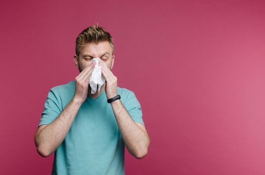 studio picture from a young man with handkerchief. Sick guy isolated has runny nose. man makes a cure for the common cold