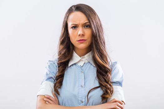 Portrait of angry businesswoman on gray background.