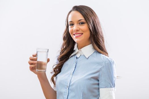 Image of beautiful businesswoman holding glass of water.