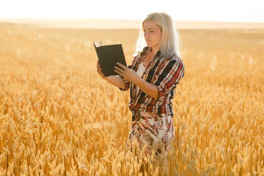 Woman holding a Bible, a natural field.