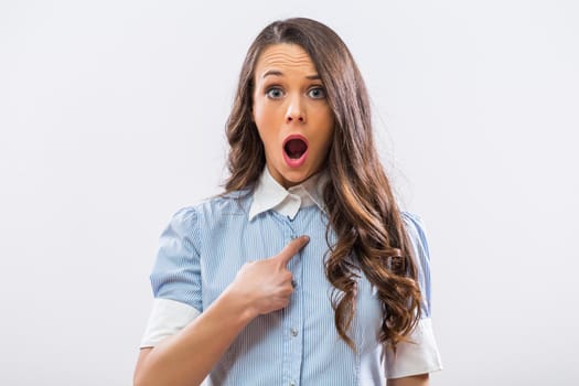 Image of shocked businesswoman pointing at herself on gray background.