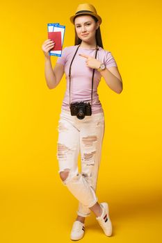 Traveler tourist woman in summer casual clothes, hat showing thumb up isolated on yellow background. Passenger traveling abroad to travel on weekends getaway. Air flight journey concept - Image