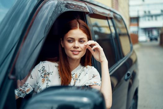 cheerful woman driving a car looks out of the window. High quality photo