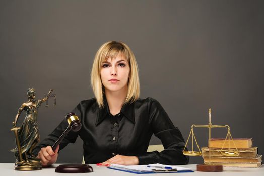 A young fair woman judge works in her office. - image