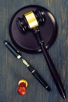 Judge's gavel, fountain pen and a stamp on an old wooden table - Image
