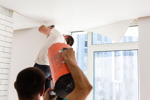 Installation of stretch ceiling. Niche for stretch ceiling. Stretch ceiling, work.