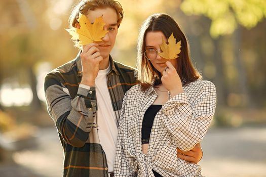Couple in a park. Guy in a white t-shirt. Golden autumn.