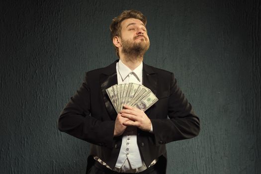 Positive man in a tailcoat hold money. - image