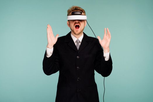 Businessman in a formal wear wearing virtual reality glasses opened his mouth in surprise - image