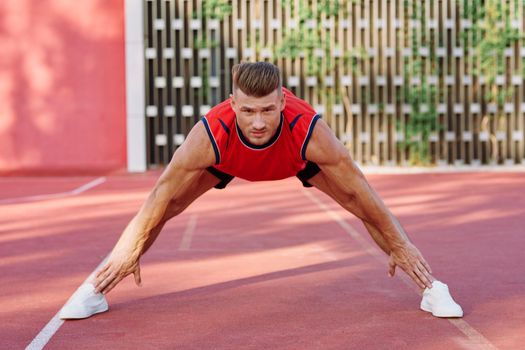 athletic man doing exercises outdoors sports field exercise. High quality photo