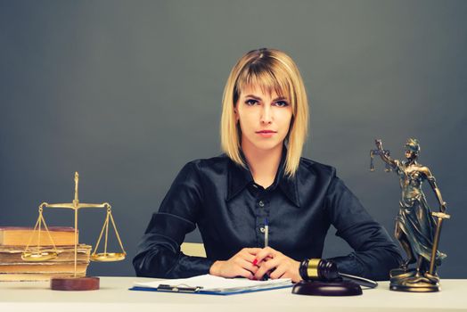 A young fair woman judge works in her office. - image toned