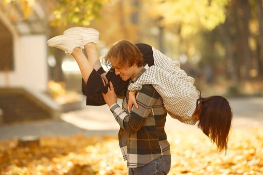 Couple in a park. Guy in a white t-shirt. Golden autumn.