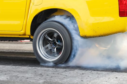 Drag racing car burns rubber off its tires in preparation for the race