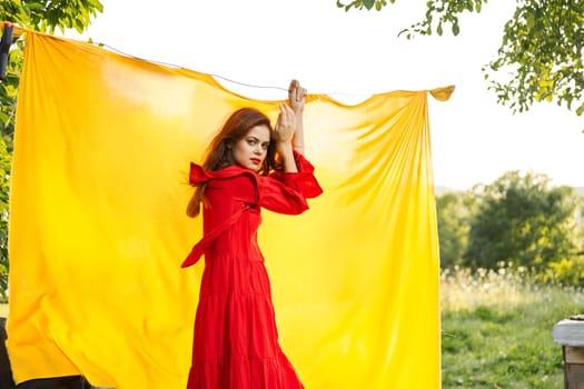 pretty woman in red dress gesturing with her hands nature yellow background. High quality photo