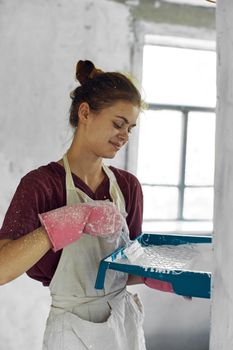 woman painter In white apron home renovation interior. High quality photo