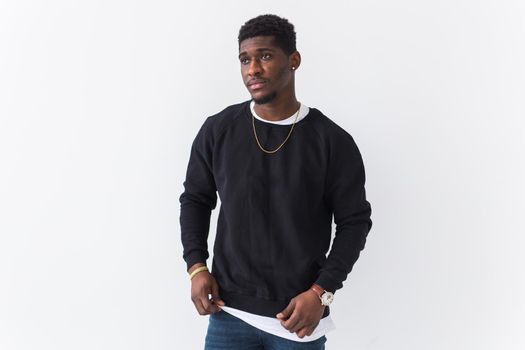 Portrait handsome young black man dressed in jeans and hoodie on white background. Street fashion and modern youth culture