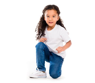 smiling little cute girl knelted on one knee isolated on white backgorund