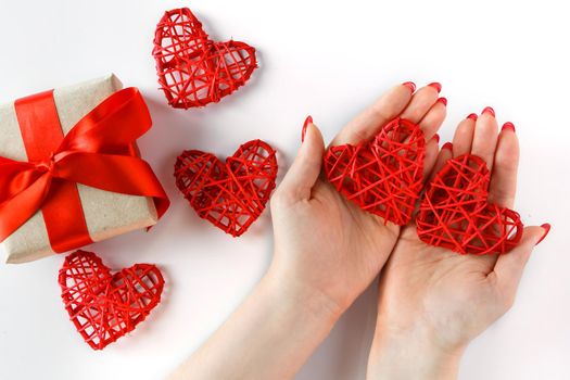 Red heart in hands on a white background. Two red hearts in hands on a white background. Symbol of love and relationships.