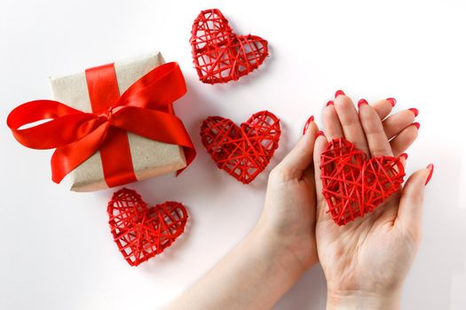 Red heart in hands on a white background. One red heart in hands on a white background. Valentine's Day Gift