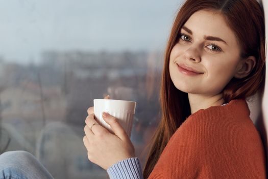 woman with hot near window in plaid rest at home. High quality photo