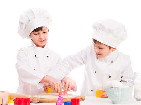 two smiling children with dough in the kitchen
