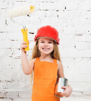 little girl-worker in orange uniform with paint and roller in hands