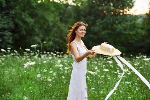 Woman in white dress hat holding flowers nature walk. High quality photo