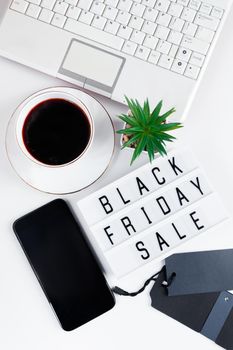 Black Friday concept. Laptop and coffee cup on white background. Online sale, discounts. Vertical format.