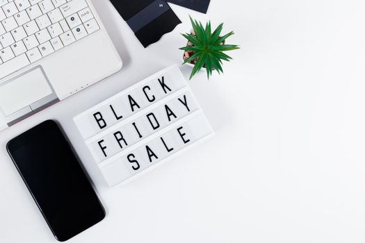 Black Friday concept. Laptop and mobile phone on white background. Online sale and discounts.