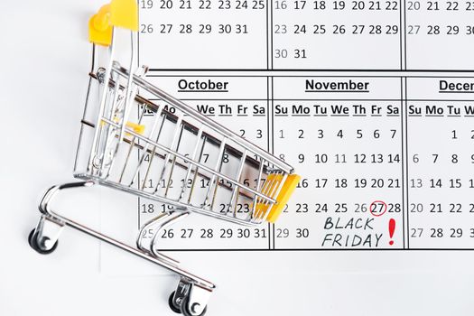 Black Friday concept - Shopping cart and calendar reminder.