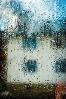 abstract image of white house through wet glass with drops