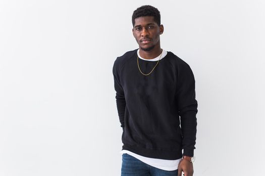 Portrait handsome young black man dressed in jeans and hoodie on white background. Street fashion and modern youth culture