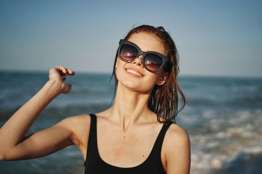 cheerful woman in black swimsuit sunglasses ocean travel. High quality photo