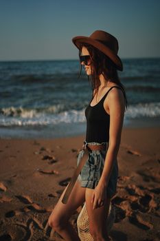 pretty woman in hat walking on the beach ocean travel. High quality photo