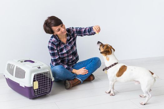 Dog carrying bags and pets owner concept - Attractive cheerful female in plaid shirt holds favourite pet. Happy woman with her jack russell terrier.