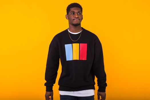 Portrait handsome young black man dressed in jeans and hoodie on white background. Street fashion and modern youth culture