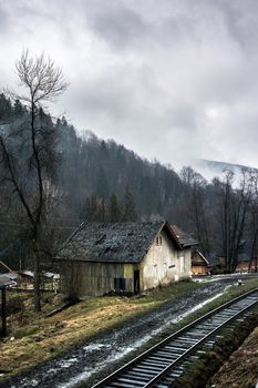 beautiful landscape with old house by railroad in Carpathian mountains, Ukraine