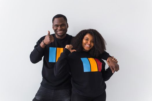 Happy African American woman and man have relationships, toothy smile, happy to meet with friends, dressed casually on white background. Emotions and friendship