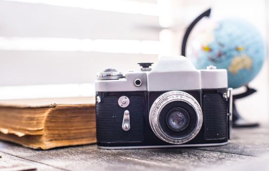 rarity camera with globe and old book on the background