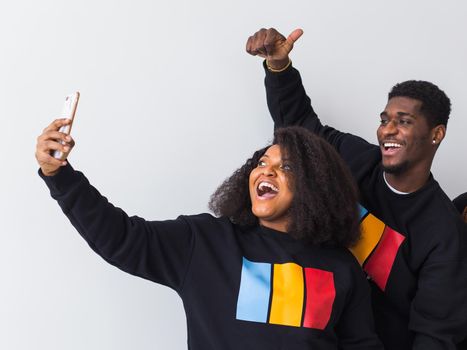 Friendship and fun concept - Group of friends afro american men and woman taking selfie in studio on white background