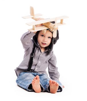 little boy with pilot hat playing toy plane isolated on white background